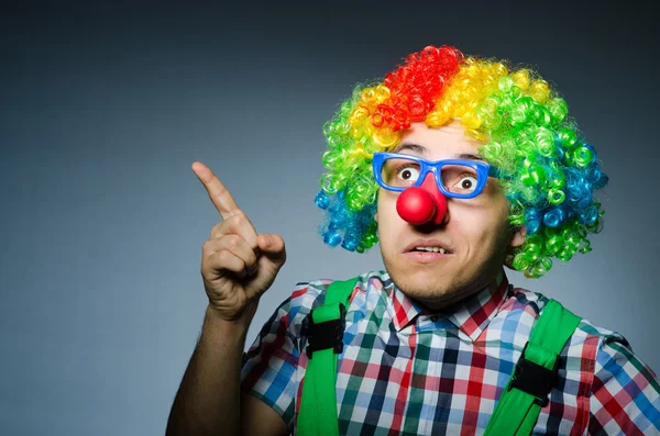 Grappige clown tegen de donkere achtergrond — Stockfoto