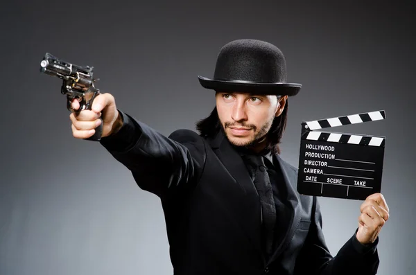 Mann mit Waffe und Filmklappe — Stockfoto