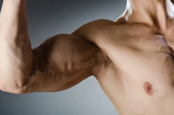 Hombre musculoso posando en estudio oscuro — Foto de Stock