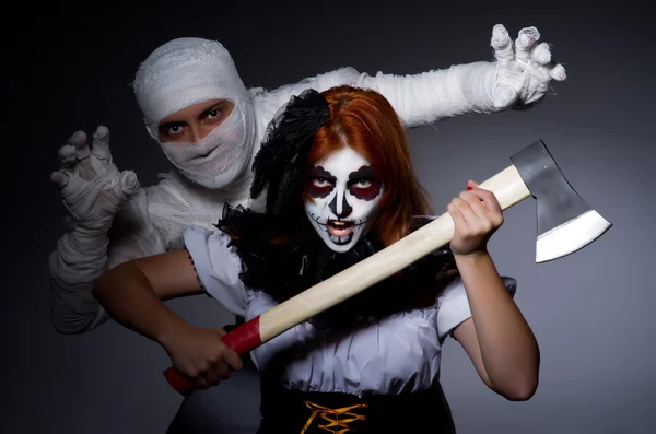 Halloween concept with mummy and woman with axe — Stock Photo, Image