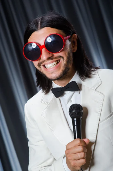 Man singing in front of curtain in karaoke concept — Stock Photo, Image