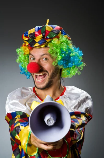 Clown with loudspealer against curtain — Stock Photo, Image