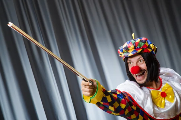 Divertido payaso plyaing violín contra cortina — Foto de Stock