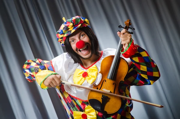 Buffo clown plyaing violino contro tenda — Foto Stock