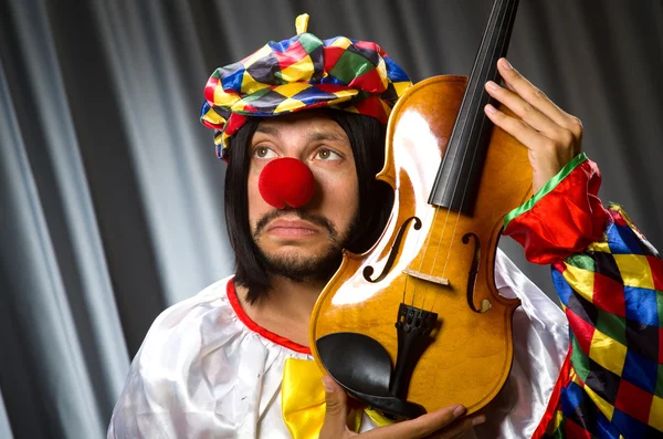Buffo clown plyaing violino contro tenda — Foto Stock