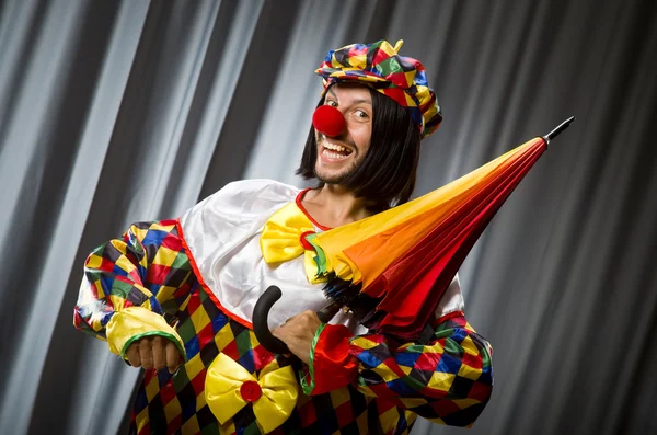 Lustiger Clown mit buntem Regenschirm — Stockfoto