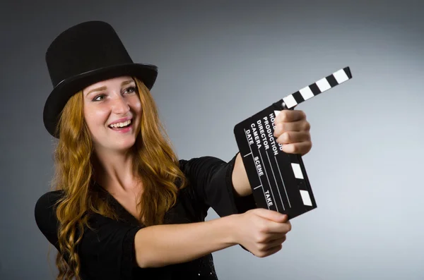 Vrouw met filmklapbord tegen grijze achtergrond — Stockfoto