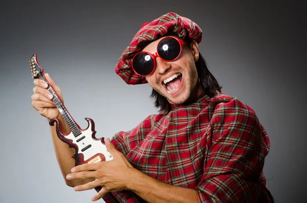Divertente scozzese che suona la chitarra rossa — Foto Stock
