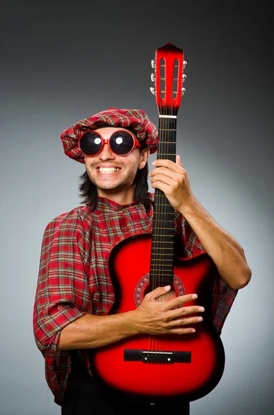 Escoteiro engraçado tocando guitarra vermelha — Fotografia de Stock