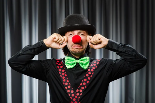 Grappige clown in humoristische concept tegen gordijn — Stockfoto