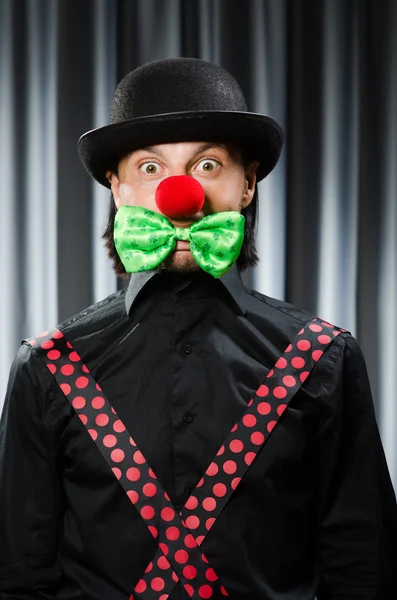 Grappige clown in humoristische concept tegen gordijn — Stockfoto