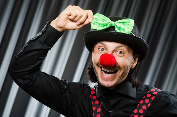 Grappige clown in humoristische concept tegen gordijn — Stockfoto
