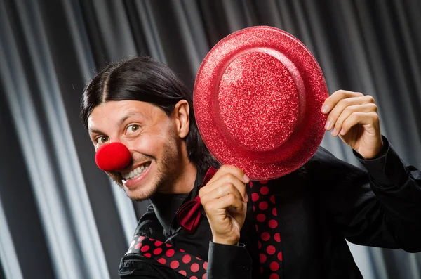 Rolig clown i humoristiskt koncept mot gardin — Stockfoto