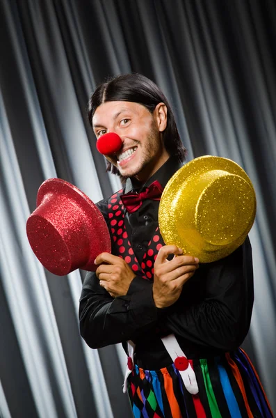 Lustiger Clown mit humorvollem Konzept gegen Vorhang — Stockfoto