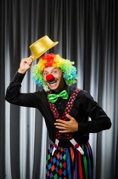 Lustiger Clown mit humorvollem Konzept gegen Vorhang — Stockfoto