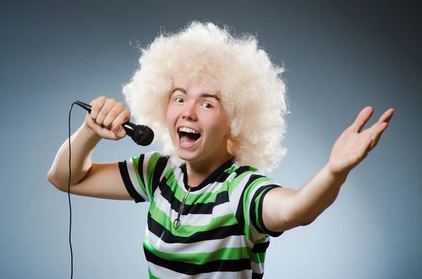 Homem de afrowig cantando com microfone — Fotografia de Stock