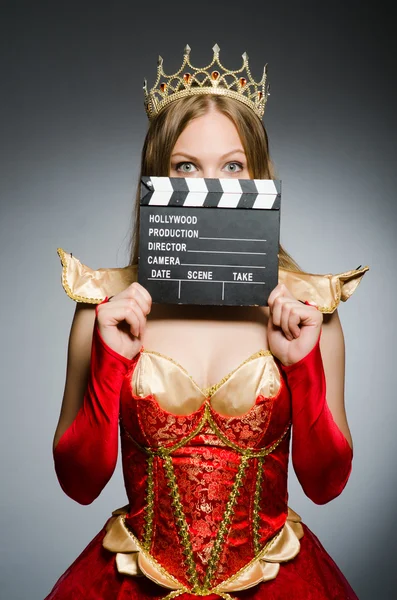 Queen in red dress with movie clapboard — Stock Photo, Image