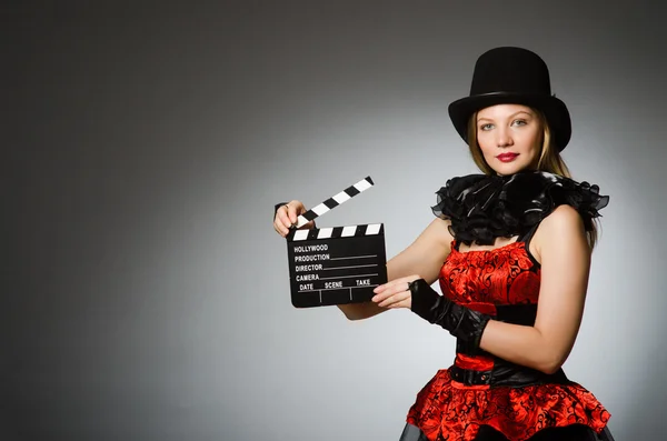 Žena s film clapboard proti šedé pozadí — Stock fotografie