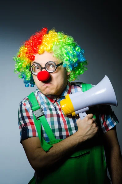 Clown with loudspealer against curtain — Stock Photo, Image