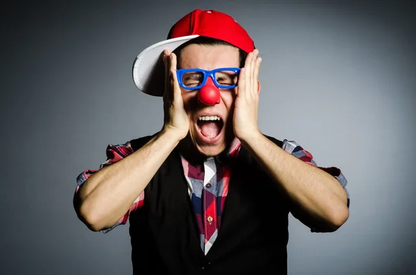 Grappige clown tegen de donkere achtergrond — Stockfoto