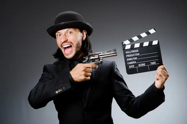 Man with gun and movie clapboard — Stock Photo, Image