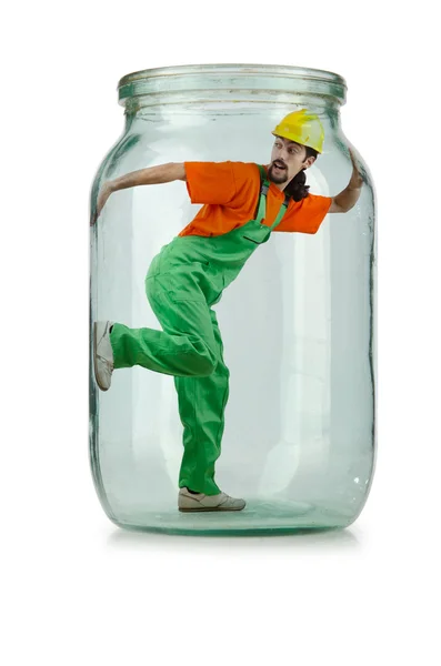 Man in coveralls imprisoned in glass jar — Stock Photo, Image