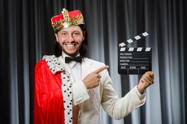 König mit Filmtafel in lustigem Konzept — Stockfoto