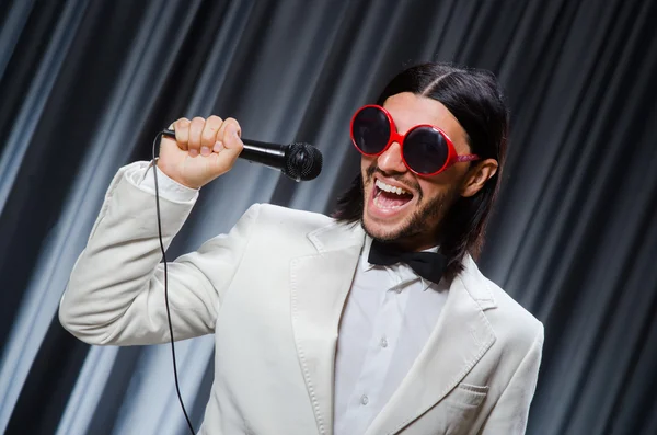 Mann singt vor Vorhang in Karaoke-Konzept — Stockfoto