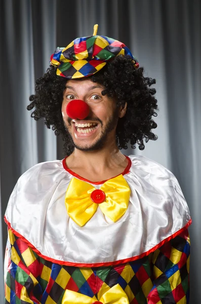 Clown divertente nel concetto umoristico contro tenda — Foto Stock