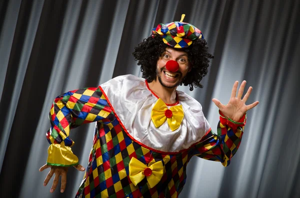 Vtipný klaun v humorném pojetí proti oponě — Stock fotografie