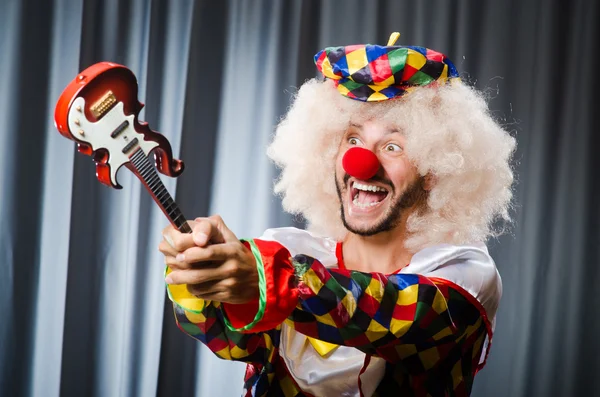 Arg clown med gitarr i roligt koncept — Stockfoto