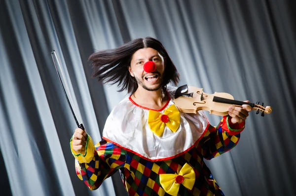 Roliga clown plyaing fiol mot gardin — Stockfoto
