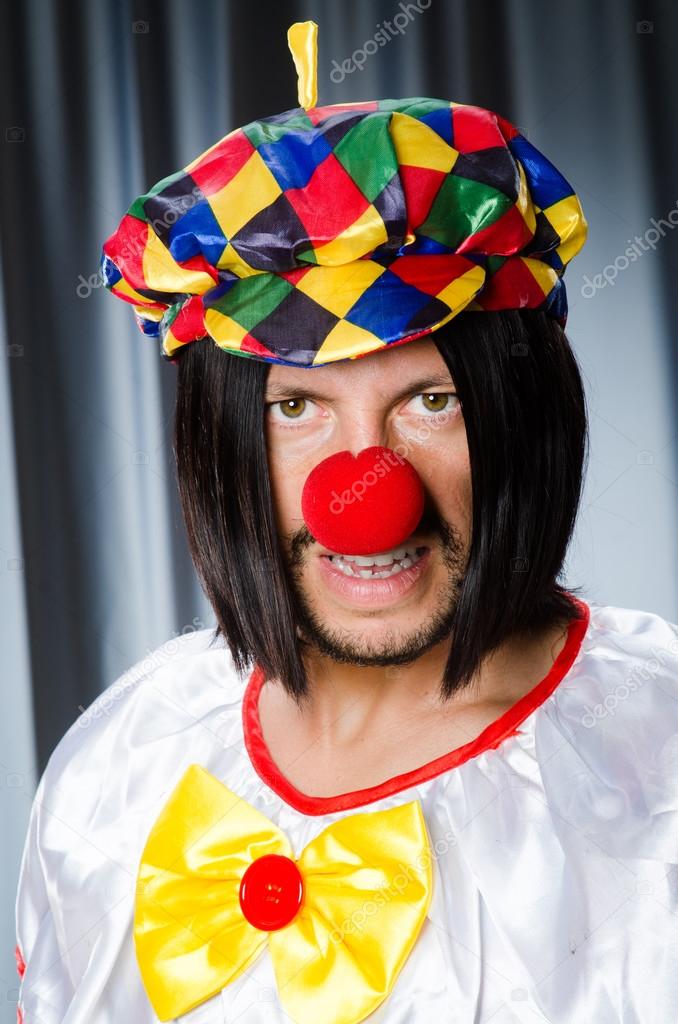 Sad clown against grey background