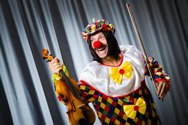 Engraçado palhaço plyaing violino contra cortina — Fotografia de Stock