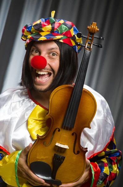 Śmieszne klaun plyaing skrzypce przed zasłoną — Zdjęcie stockowe