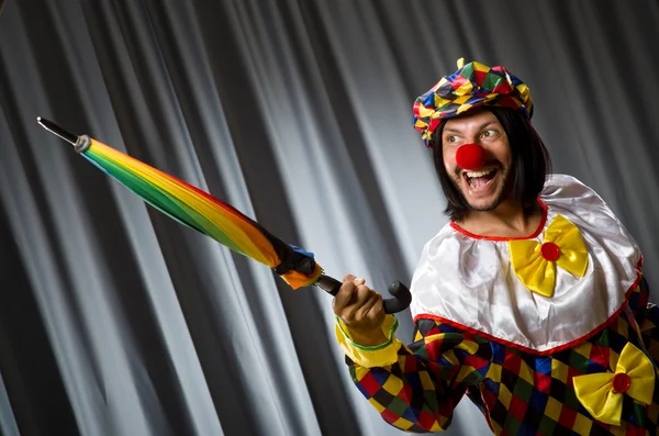 Grappige clown met kleurrijke paraplu — Stockfoto