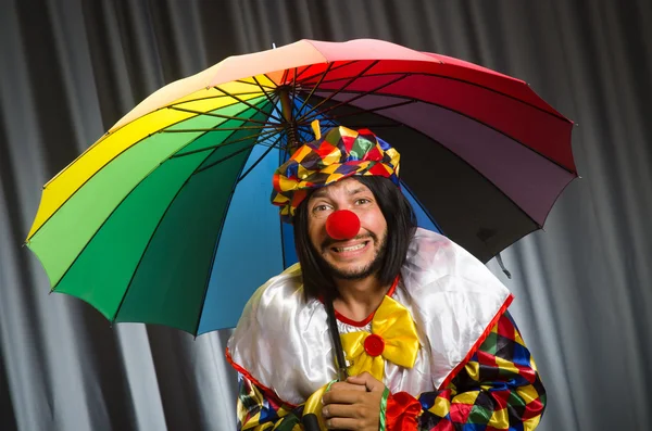 Grappige clown met kleurrijke paraplu — Stockfoto