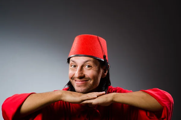 Grappige mens in rode jurk dragen van fez hoed — Stockfoto