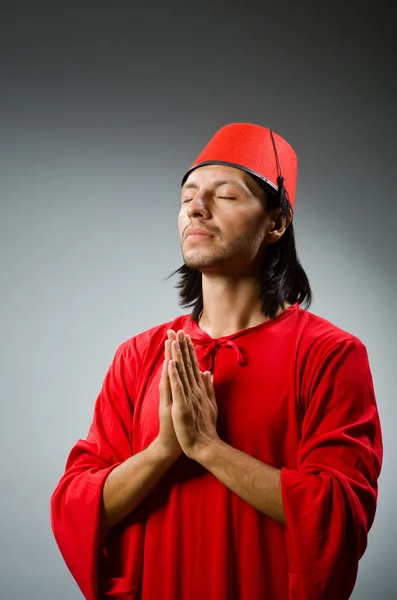 Άντρας με κόκκινο φόρεμα φοράει καπέλο φέσι — Φωτογραφία Αρχείου