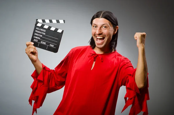 Man in red dress with movie clapboard — Stock Photo, Image