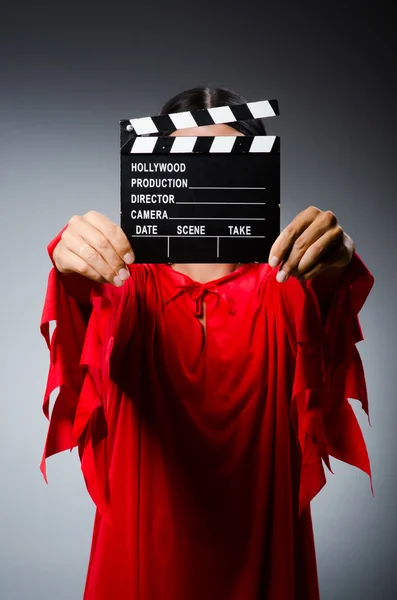 Mann im roten Kleid mit Filmklappe — Stockfoto