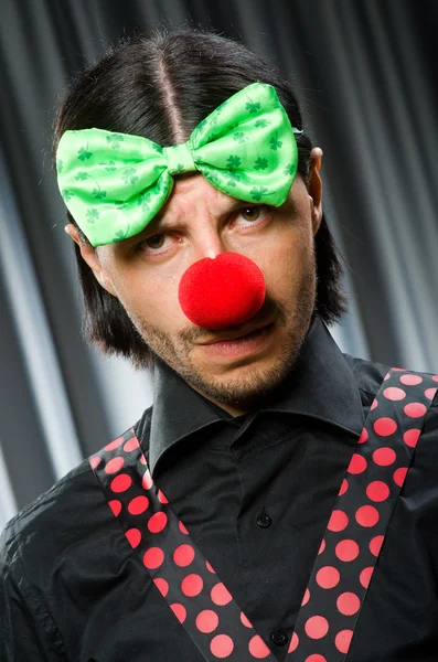 Clown divertente nel concetto umoristico contro tenda — Foto Stock