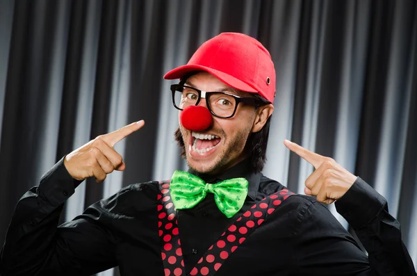 Grappige clown in humoristische concept tegen gordijn — Stockfoto