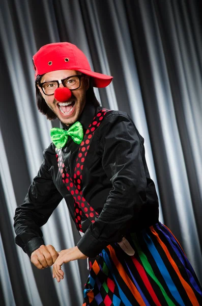 Rolig clown i humoristiskt koncept mot gardin — Stockfoto