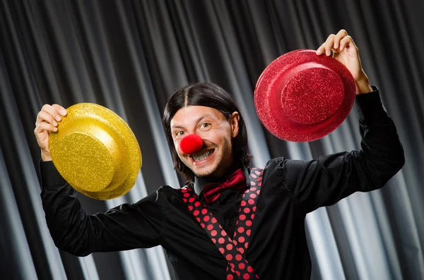 Lustiger Clown mit humorvollem Konzept gegen Vorhang — Stockfoto