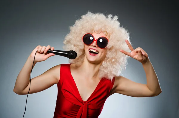 Junge Frau mit Mikrofon im Musikkonzept — Stockfoto