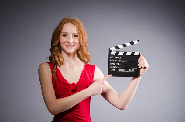 Film tahtası olan kırmızı elbiseli bir kadın. — Stok fotoğraf