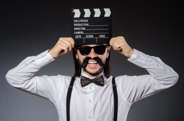 Elinde film tahtası olan komik bir adam.