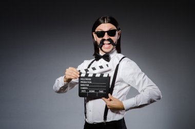 Elinde film tahtası olan komik bir adam.