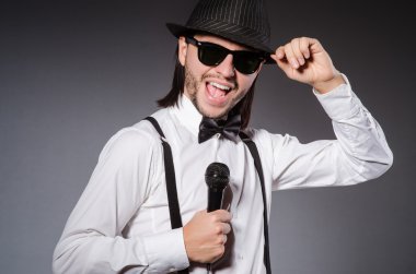 Konserde mikrofonlu komik bir şarkıcı.